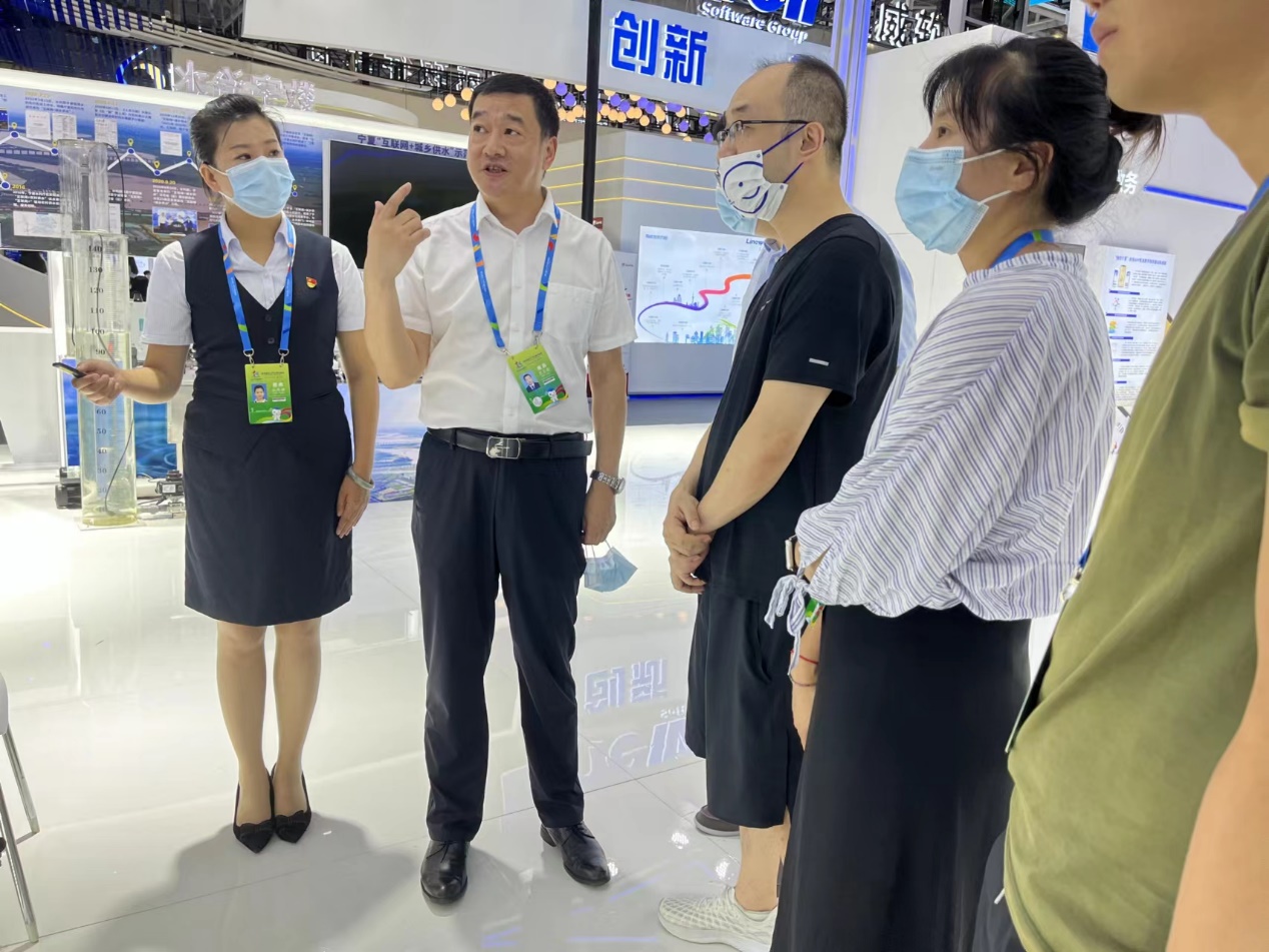 寧夏人社廳信息數(shù)據(jù)管理中心主任花自榮（左二）為觀展群眾現(xiàn)場講解。寧夏人力資源和社會保障廳供圖