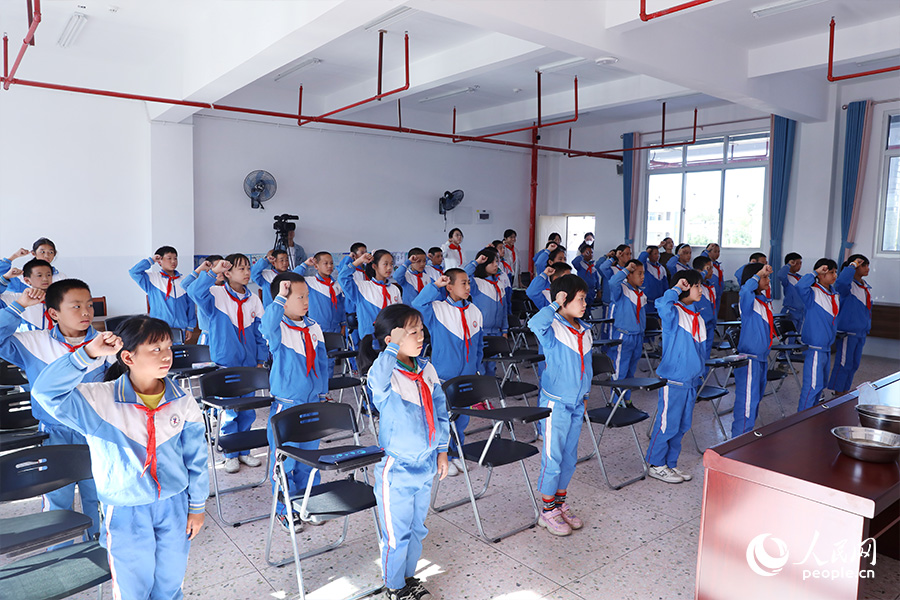 孩子們握拳宣讀《校園節(jié)水倡議書》。人民網(wǎng) 陳永整攝