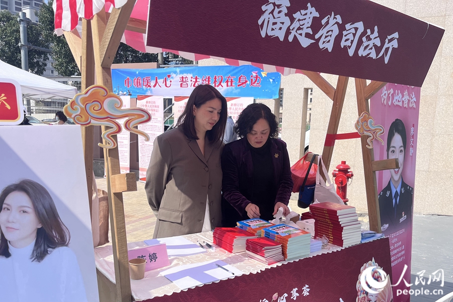 “蒲公英”普法志愿者向群眾發(fā)放婦女權(quán)益保障法等法律及普法宣傳書籍。人民網(wǎng) 錢嘉禾攝