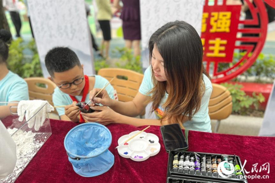 校園操場(chǎng)上，家長(zhǎng)正帶領(lǐng)著孩子共同手工DIY陶土。人民網(wǎng) 錢(qián)嘉禾攝