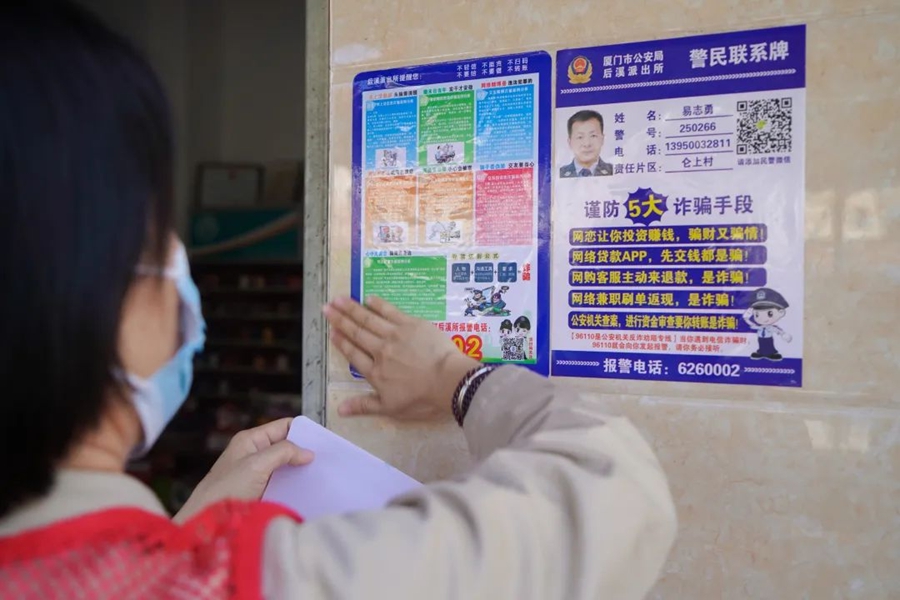社區(qū)工作者張貼反詐宣傳單。集美區(qū)融媒體中心供圖