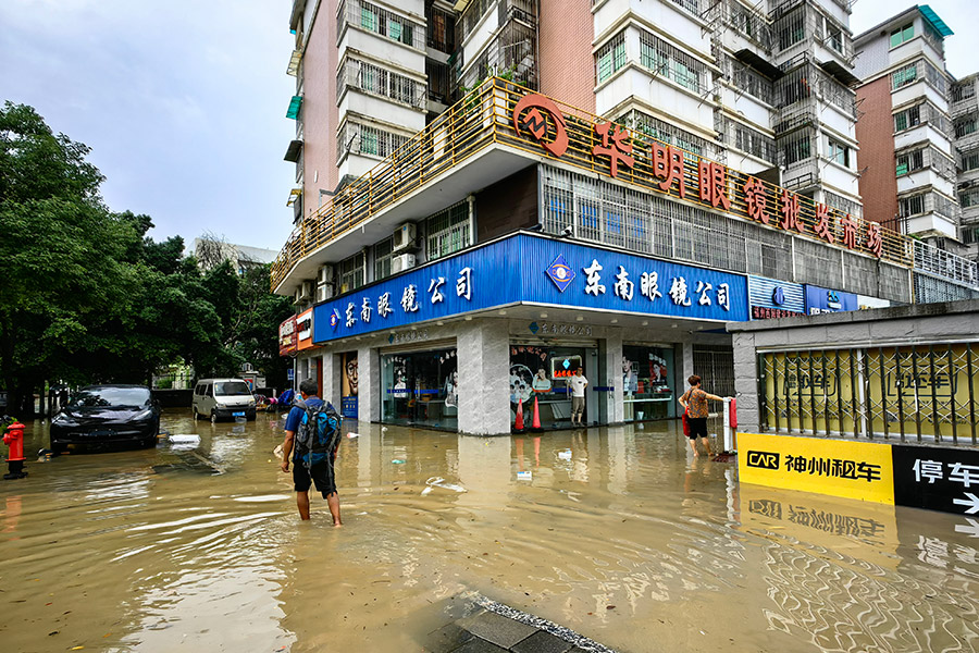 今早六時(shí)左右，福州西園路口積水較為嚴(yán)重，行人只能蹚水前行。雍萬俊攝