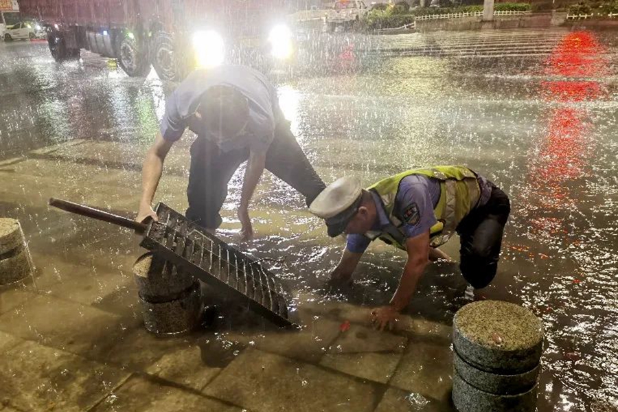 莆田市涵江區(qū)交警大隊民警對城涵東大道積水嚴重區(qū)域進行清淤排水。莆田市公安局供圖