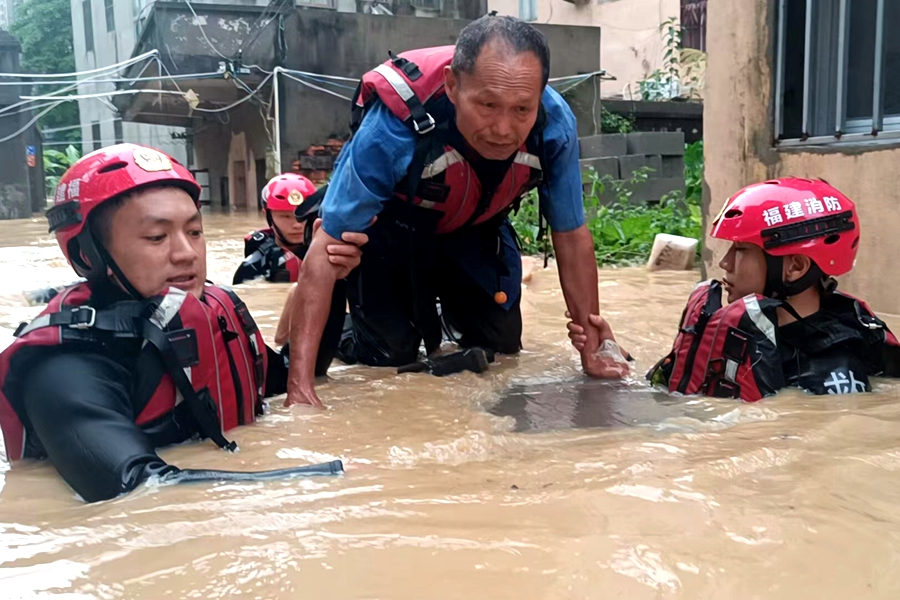 消防救援人員用身體支撐木板護送福清受困群眾轉(zhuǎn)移。福建消防供圖
