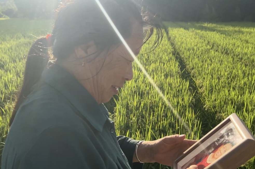 拿到自己照片的老人，細(xì)細(xì)端詳著照片。受訪者供圖