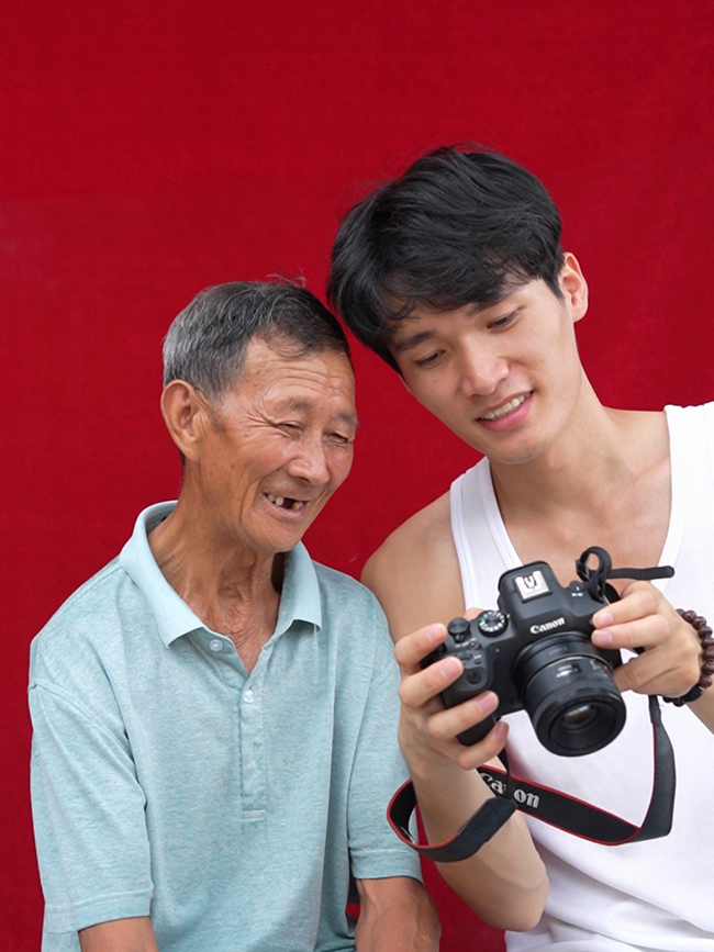 吳木良給老爺爺展示拍照成果。受訪者供圖