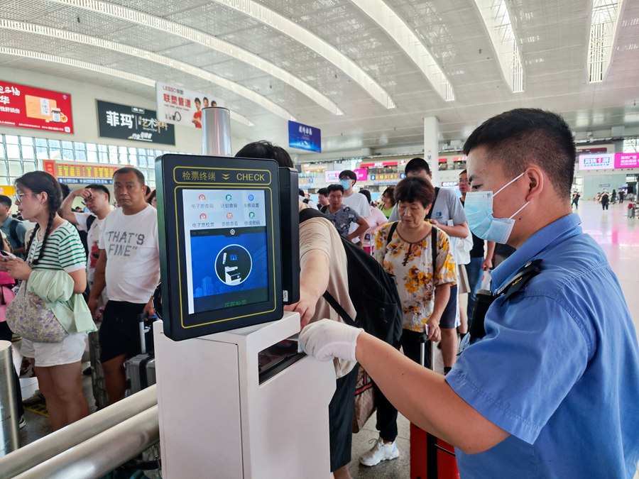 工作人員引導(dǎo)旅客檢票進(jìn)站。韓毅攝