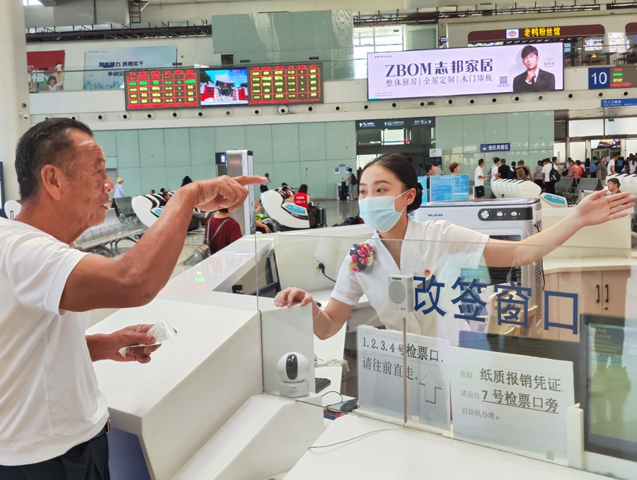 服務(wù)臺(tái)工作人員為旅客解答咨詢。韓毅攝