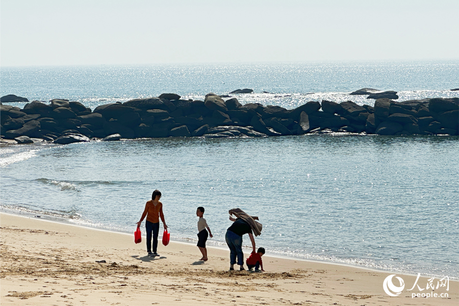 12月9日，泉州石獅市“十里黃金海岸”海邊，游客流連忘返。人民網(wǎng)記者 劉卿攝