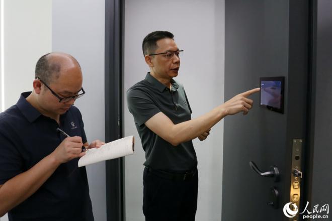 施米德科技負(fù)責(zé)人正在介紹一款創(chuàng)新型智能門。人民網(wǎng)記者 陳博攝