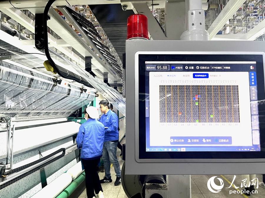 AI智能檢測(cè)系統(tǒng)正在檢測(cè)東龍針紡坯布上的瑕疵。人民網(wǎng)記者 陳藍(lán)燕攝