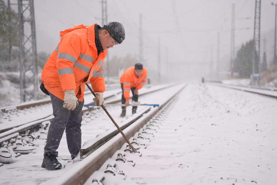 1月22日，在南平市武夷山黃連坑站，作業(yè)人員在雪中檢查道岔設(shè)備，確保正常使用。潘文暉攝
