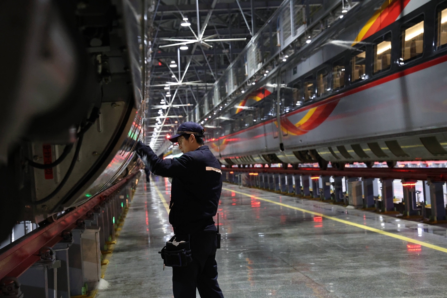 動車組機械師正在對車組兩側(cè)進行檢查。 譚文卿攝