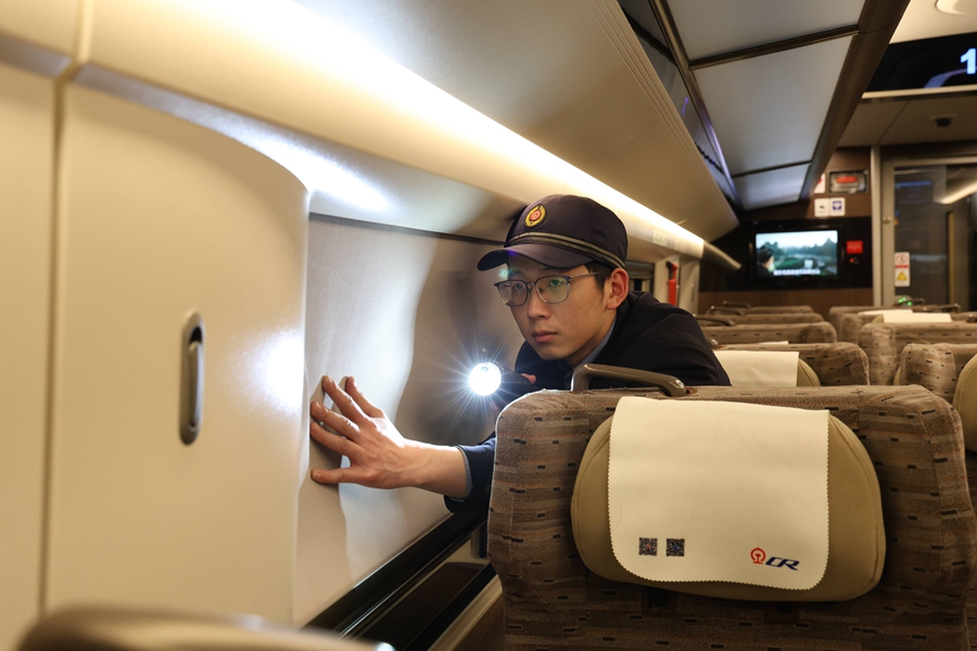 動車組機械師正在對頭燈進行確認。  譚文卿攝