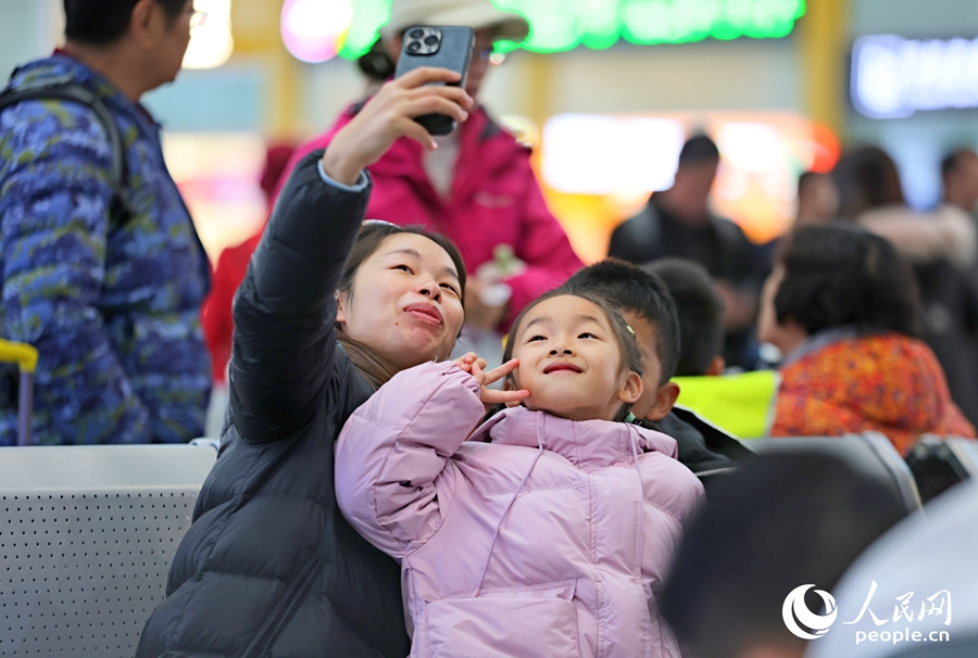 乘客在廈門(mén)北站候車(chē)室里合影，發(fā)送給遠(yuǎn)方的家人。人民網(wǎng)記者 陳博攝