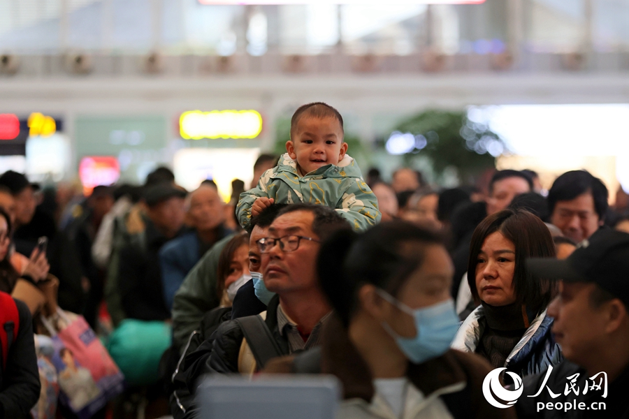 廈門(mén)北站候車(chē)閘口前排起長(zhǎng)隊(duì)，一位小乘客“登高遠(yuǎn)望”。人民網(wǎng)記者 陳博攝