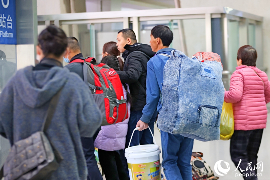 隨著列車(chē)駛?cè)霃B門(mén)北站，乘客們背著大包小包的行李奔向月臺(tái)，踏上新年回家路。人民網(wǎng)記者 陳博攝