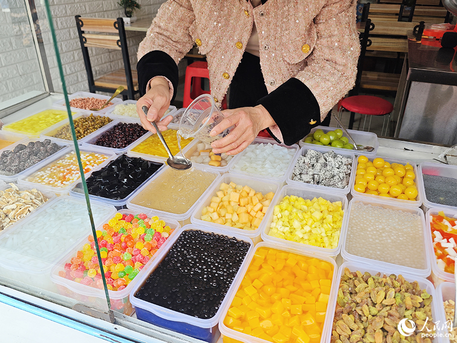 賣四果湯的老板娘正在調(diào)配飲料。人民網(wǎng) 黃東儀攝