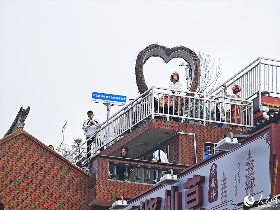 游客登上臨街天臺尋找最佳拍攝角度。人民網(wǎng) 黃東儀攝