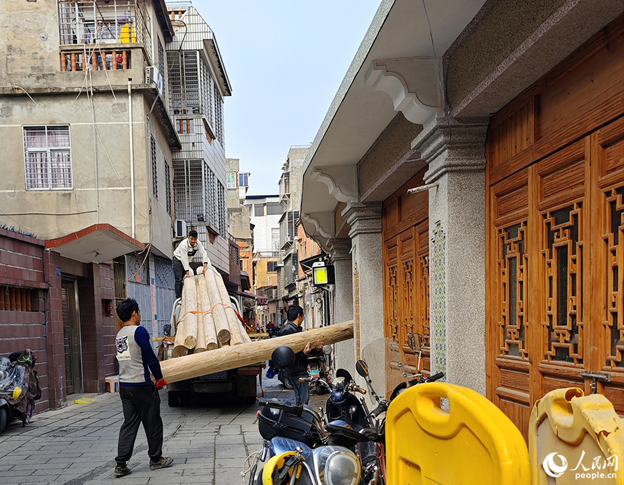 工作人員正在搬運(yùn)修復(fù)古民居所用的木料。人民網(wǎng) 黃東儀攝