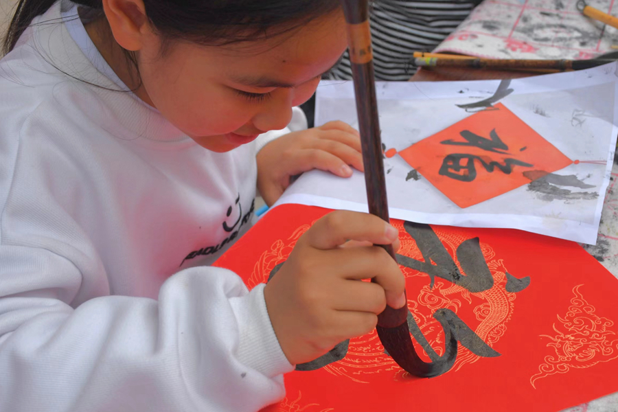 在檳榔社區(qū)，小女孩拿起毛筆書寫“福”字。楊金木攝