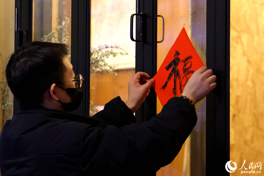 一位市民將DIY的“?！弊执郝?lián)貼在窗戶上。人民網(wǎng)記者 陳博攝