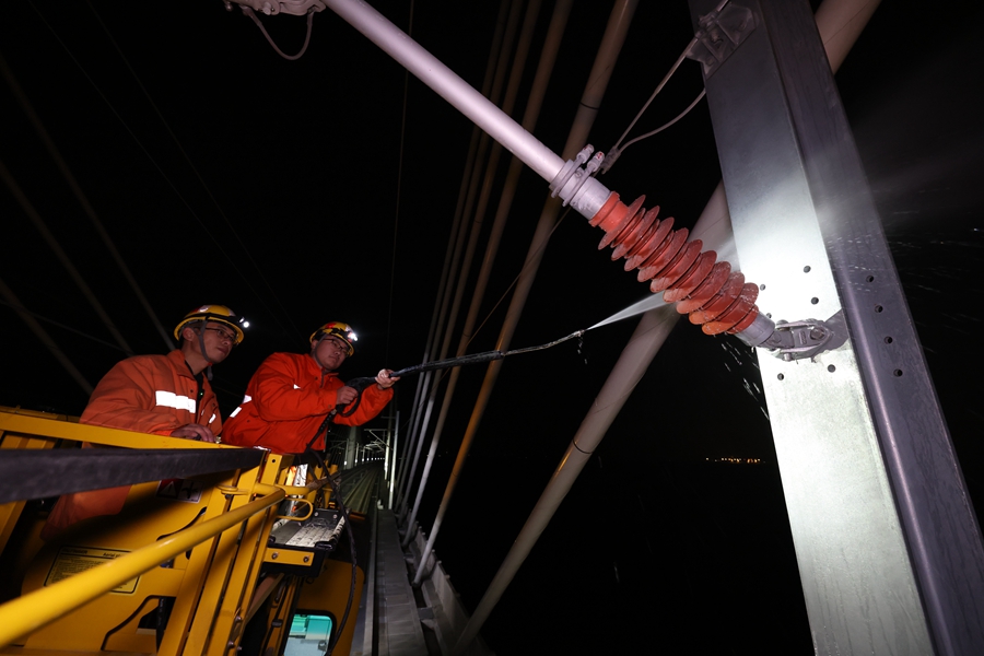 海上鹽分高、濕度大，鹽分很容易附著絕緣子上，接觸網(wǎng)工們必須定期對(duì)大橋上的絕緣子進(jìn)行沖洗。胡鵬攝