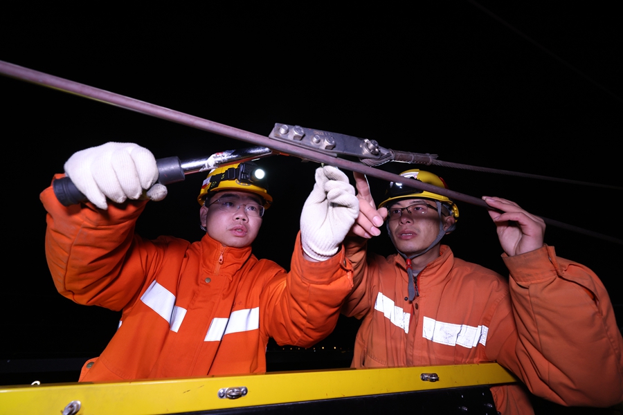 莆田高鐵供電工區(qū)工長(zhǎng)許沖（右）和工友在檢查接觸網(wǎng)供電設(shè)備。胡鵬攝.