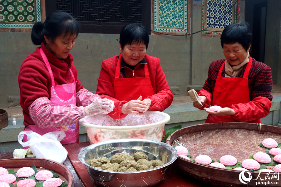 抓取手心大小的面團，將蒸好的綠豆或甜糯米揉搓成球、壓印成型。人民網(wǎng)記者 林盈攝