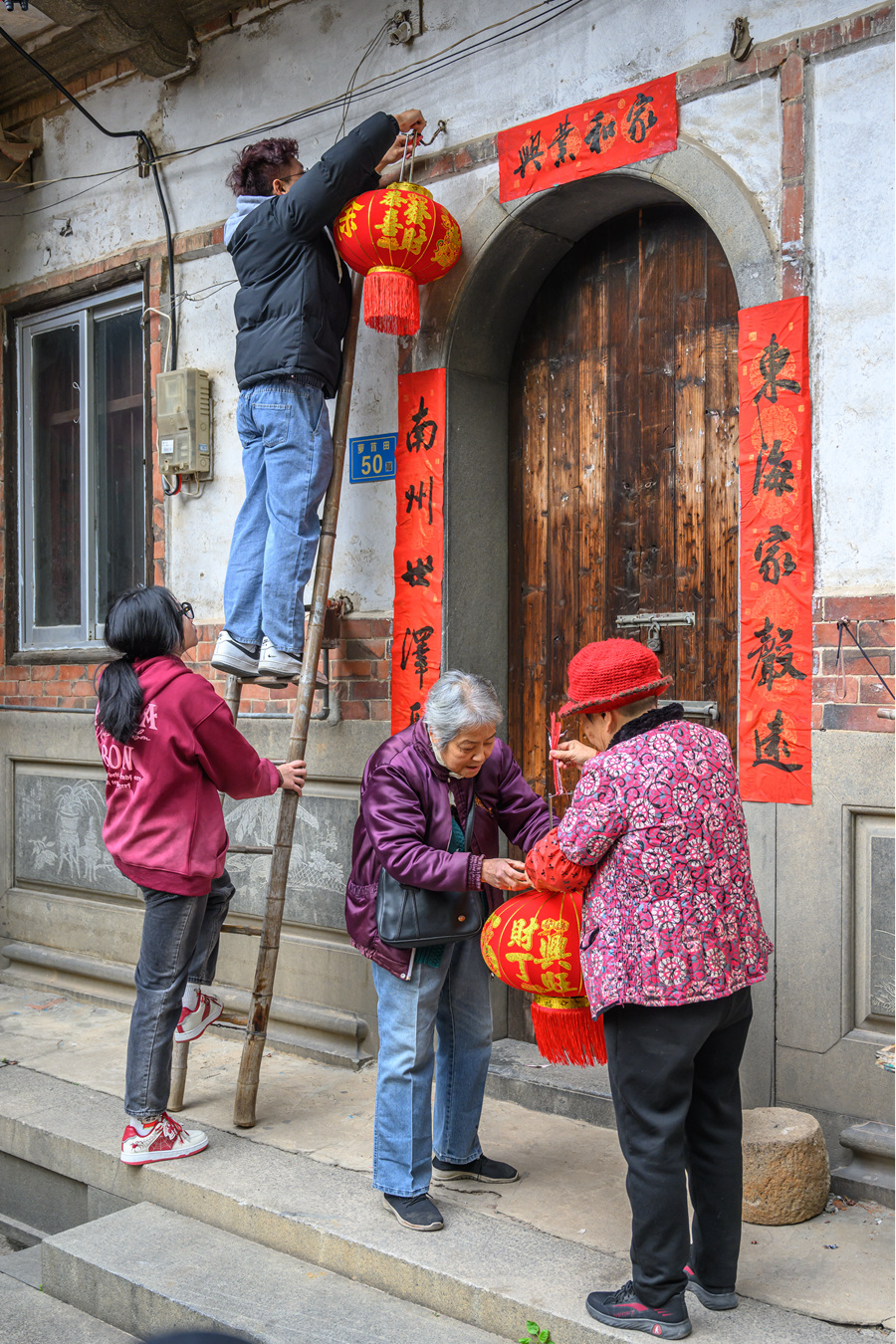 貼春聯(lián)、掛燈籠，老厝新春年味濃。蔡昊攝