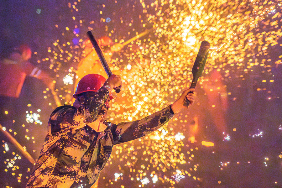 匠人將鐵水用特制的竹片潑灑到荔枝樹枝葉上。蔡昊攝