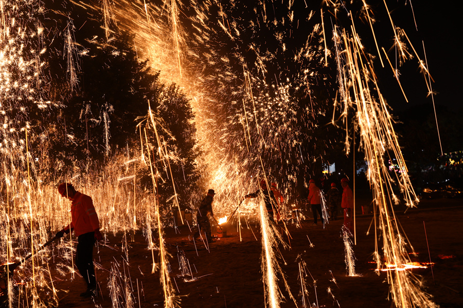 細(xì)碎的火星在空中翻滾，劃出金色明亮的弧線。姚文峰攝