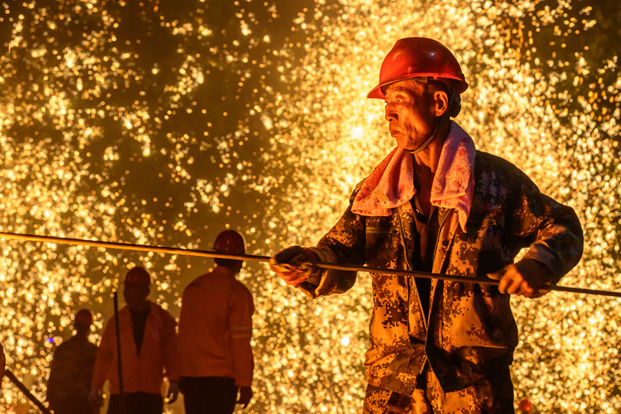 鐵砂需經(jīng)高溫融為鐵水，用于拋灑表演。蔡昊攝