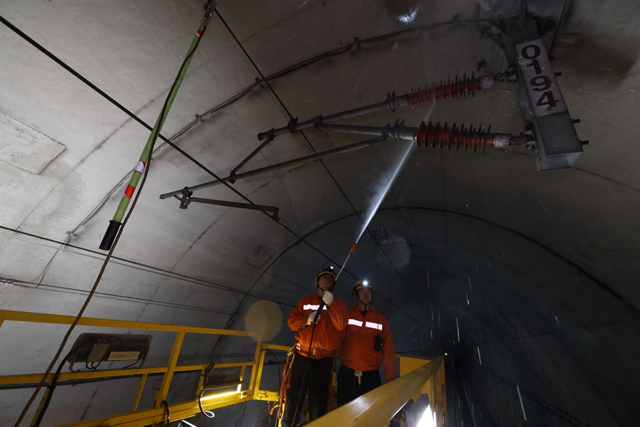 由于隧道內(nèi)灰塵較大，作業(yè)人員使用清洗機沖洗絕緣子表面的臟污。胡鵬攝