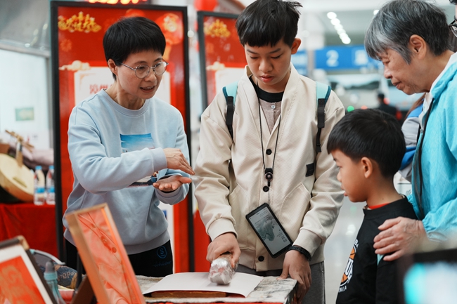 旅客朋友在漳州站文化圩市里體驗(yàn)制作木版年畫。陳明 攝.jpg