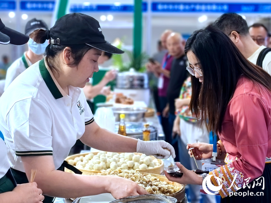 一位參展企業(yè)工作人員在向觀展者介紹產(chǎn)品。人民網(wǎng)記者 林曉麗攝