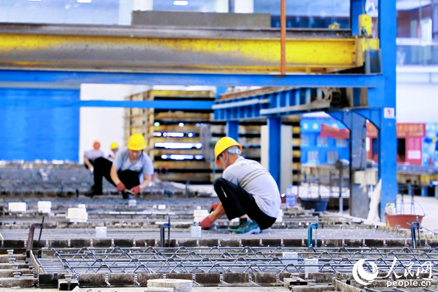 批量澆筑前，工人正在捆綁鋼筋。人民網(wǎng) 李唯一攝