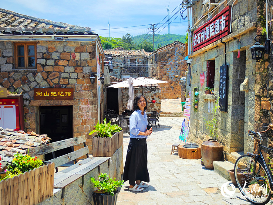 民宿主理人戴小姐（臺(tái)灣）站在文創(chuàng)空間外的石板路上。人民網(wǎng) 黃東儀攝