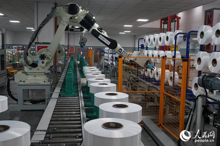 恒申集團(tuán)工廠(chǎng)車(chē)間內(nèi)，機(jī)械臂正在作業(yè)。人民網(wǎng)記者 蘭志飛攝