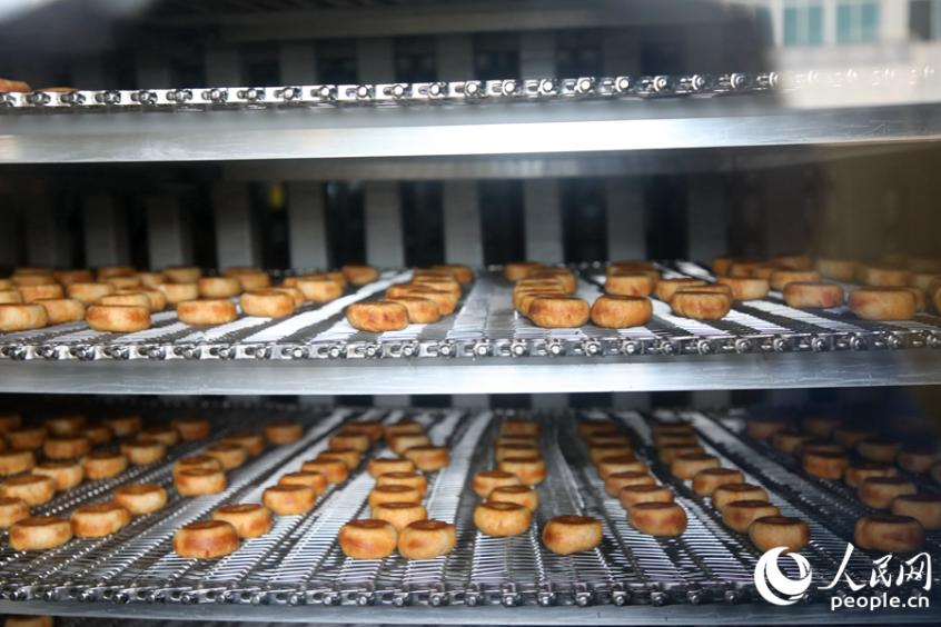 新鮮出爐的肉松餅，經(jīng)過冷卻工序后，正輸送至分裝環(huán)節(jié)。人民網(wǎng) 李昌乾攝