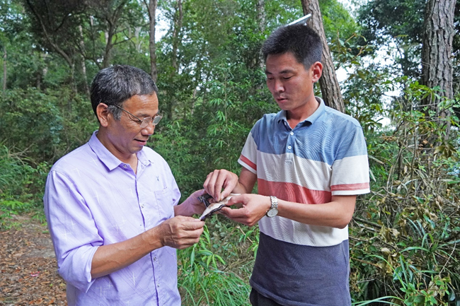 林宜達(dá)（右）在查看靈芝長(zhǎng)勢(shì)。羅姮攝