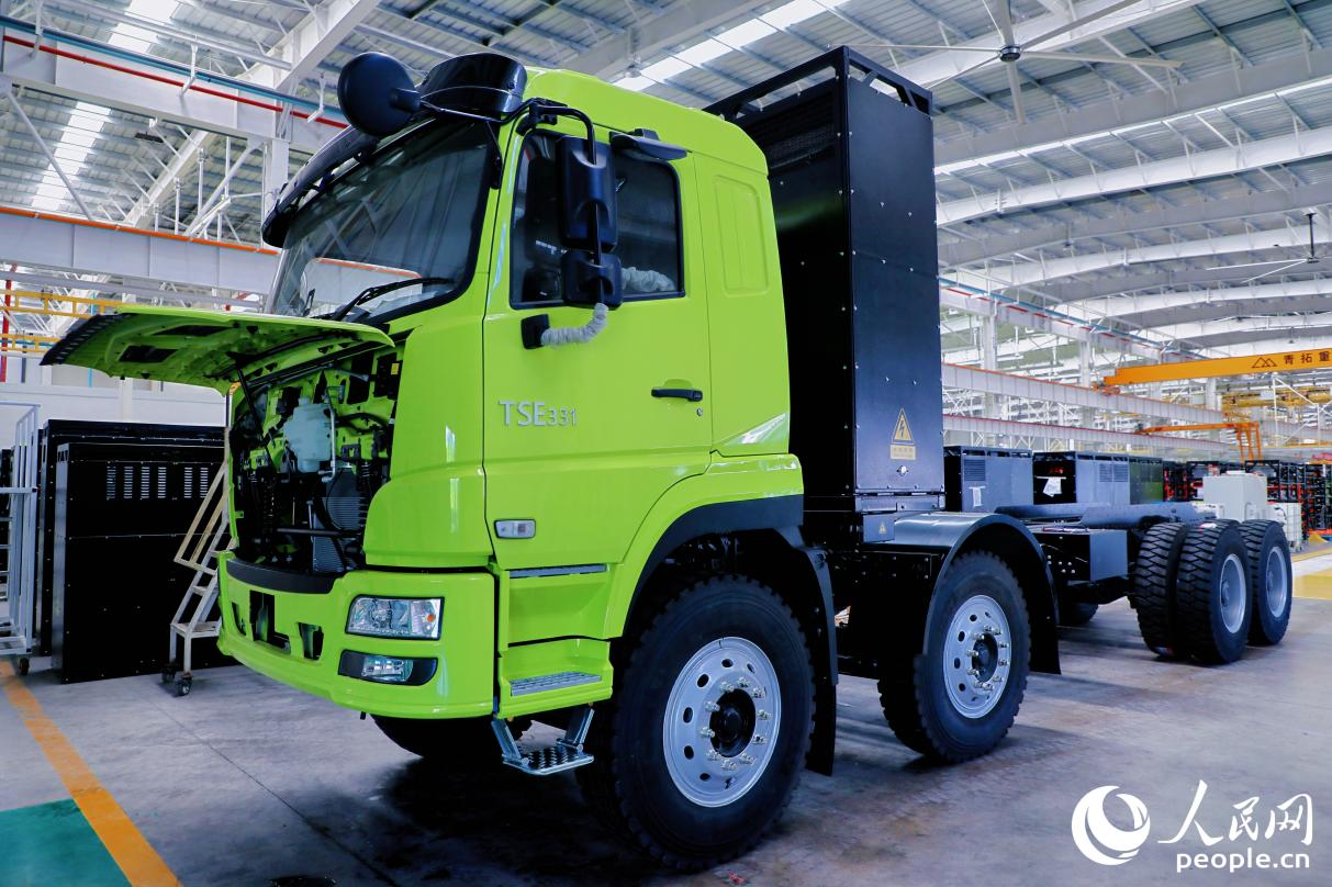 這是車間流水線上等待裝配貨箱的新能源礦卡，搭載的電池位于車頭與貨箱之間。人民網(wǎng) 李唯一攝