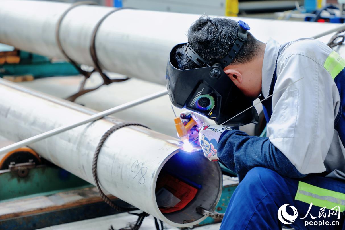 青山鋼管福建分公司車間內(nèi)，員工正在將鋼管整圓。人民網(wǎng) 李唯一攝