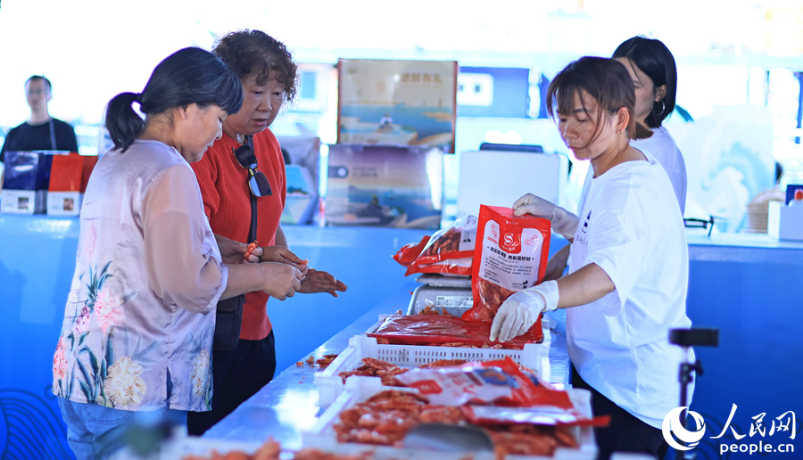 10.在澳角村，游客采購當(dāng)?shù)睾ｕr加工產(chǎn)品。人民網(wǎng) 李昌乾攝