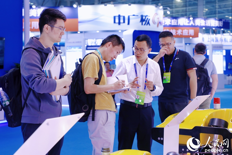 觀眾一邊同參展商交流一邊記筆記。人民網(wǎng) 李唯一攝