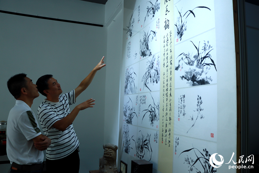 書畫愛好者高泗勇（左）與友人在交流書畫藝術(shù)。人民網(wǎng) 蘇海森攝