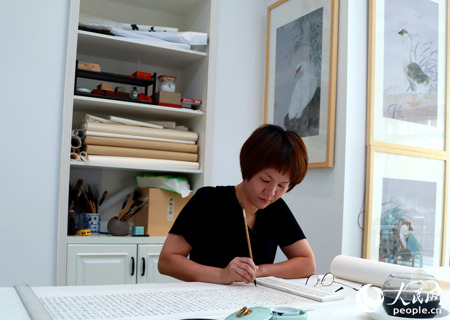 既是全職媽媽又是業(yè)余書畫家的陳利娟正在創(chuàng)作。人民網(wǎng) 蘇海森攝