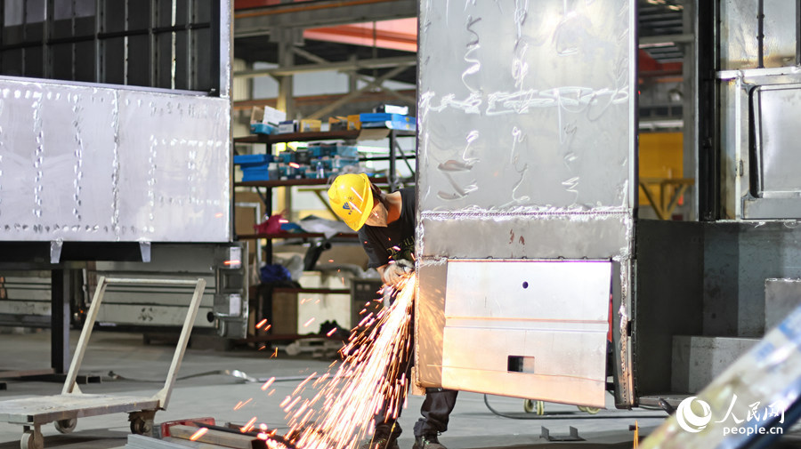 在暢豐專汽生產(chǎn)車間，機(jī)器聲此起彼伏，打磨的火花四濺，火光映照著工人們忙碌的身影。人民網(wǎng) 李昌乾攝