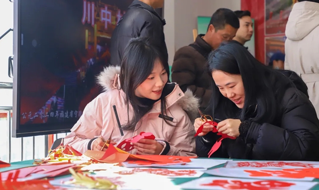 市民游客在展區(qū)體驗剪紙