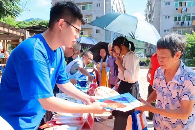 “法小穗”青年志愿者為群眾發(fā)放普法宣傳冊